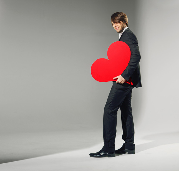Portrait of the young man holding heart - Foto, Imagen