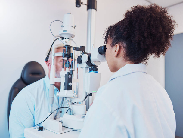Optometrie, oční vyšetření a oftalmolog testující pacientovo vidění nebo oči pomocí štěrbinového lampy od lékaře. Zdravotnictví, oční a zdravotní pojištění profesionál dělá vizuální vyšetření na člověka. - Fotografie, Obrázek