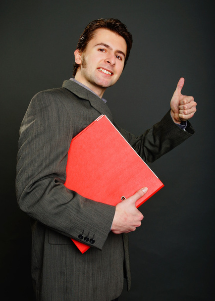 Man in suit holds red worktops - Foto, Imagen