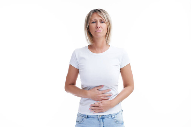 Immagine di donna bionda sul retro sfondo isolato con problemi di stomaco. Foto di alta qualità - Foto, immagini