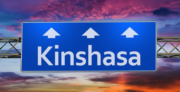 Znak drogowy wskazujący kierunek do miasta Kinszasa. - Zdjęcie, obraz