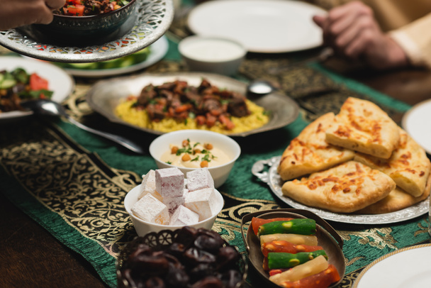 Vue sur les cultures de délicieux aliments près de la famille musulmane pendant le dîner du ramadan  - Photo, image
