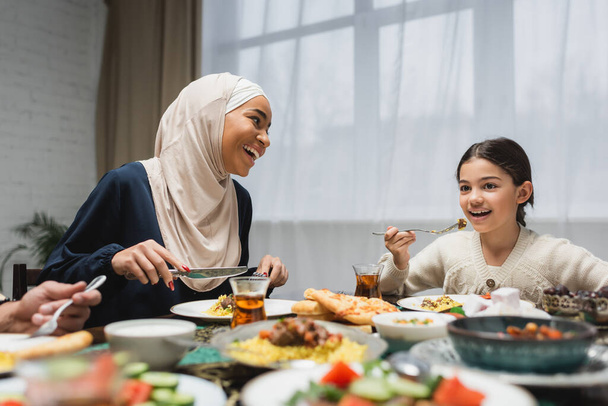 Улыбающаяся ближневосточная семья ужинает ифтаром во время рамадана  - Фото, изображение