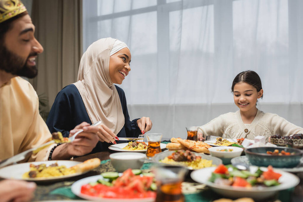 Улыбающаяся ближневосточная семья разговаривает во время Рамадана дома  - Фото, изображение