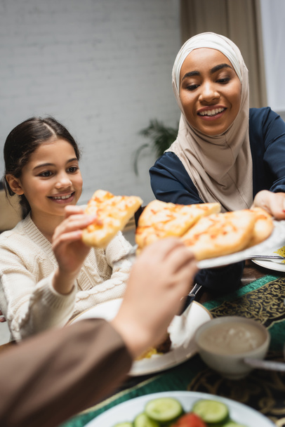 African american woman in hijab holding pita bread near kids during ramadan  - Foto, Imagen