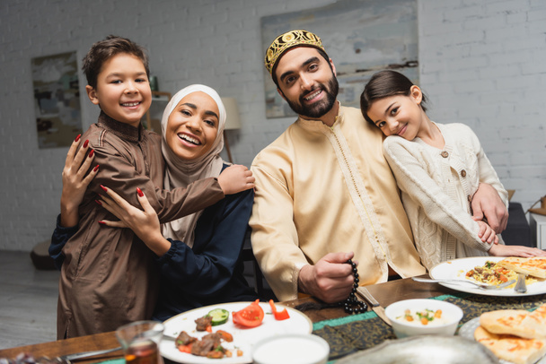 Famille du Moyen-Orient embrasser les enfants pendant le dîner ramadan à la maison  - Photo, image