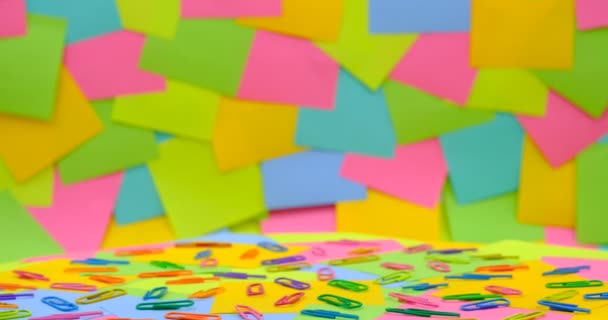 Разноцветные скрепки бумаги на вращающемся столе с разноцветной бумагой Sticky Notes, разместить его - Кадры, видео