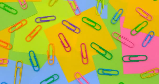 Разноцветные скрепки бумаги на вращающемся столе с разноцветной бумагой Sticky Notes, разместить его - Кадры, видео