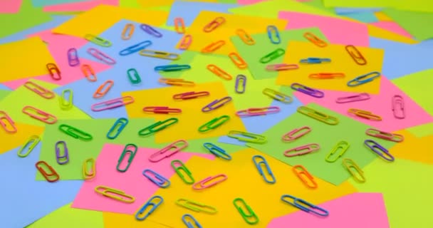 Kolorowe spinacze do papieru na obracającym się stole z kolorowym papierem Notatki lepkie, publikuj - Materiał filmowy, wideo