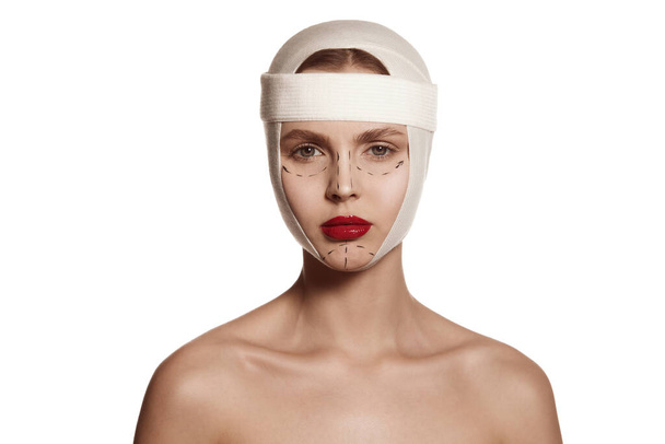 Lifting, therapy concept. Female face bandaged with medical bandages and human emotions concepts. Making beauty, modifying face to make surgical correction, plastic surgery. correction of asymmetry. - Photo, image