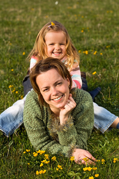 Woman and little girl on the spring meadow - Foto, imagen