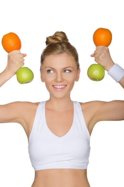 young woman with dumbbells fruits looking away - Photo, image