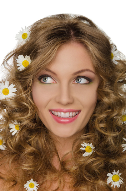 young woman with daisies in curly hair looks away - Foto, Imagen