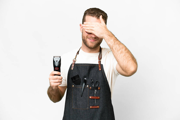 Barber man in an apron over isolated white background covering eyes by hands. Do not want to see something - 写真・画像