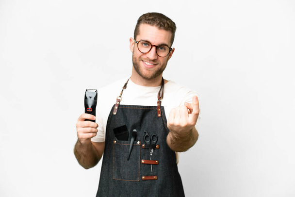 Barber man in an apron over isolated white background doing coming gesture - Foto, Imagen