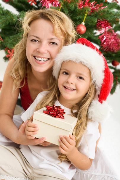 Merry christmas - woman and little girl with a present - 写真・画像