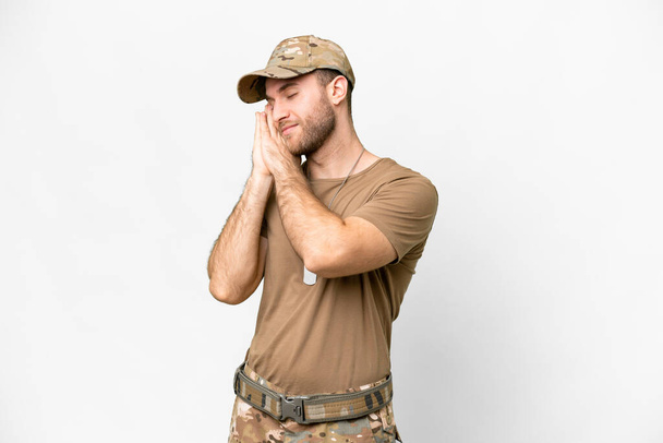 Military with dog tag over isolated white background making sleep gesture in dorable expression - Foto, imagen