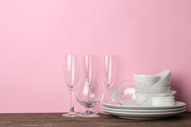 many different dishes. Dinnerware. on a pink background. utensils for table setting. various plates, bowls and cups. - Foto, imagen