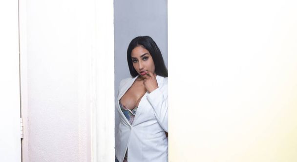 sensual latina mulher atrás da porta em pose provocante - Foto, Imagem