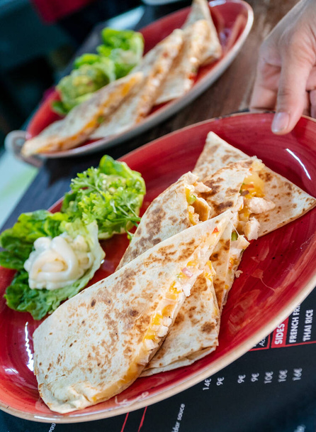 wizerunek pary quesadillas z kurczakiem i krewetkami serwowanych z jogurtem i awokado dipów  - Zdjęcie, obraz