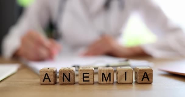 Anemia is written on wooden cubes on the doctor table, a close-up. Blood diseases, medical consultation - Materiaali, video