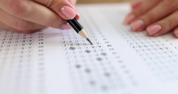 Macro mains féminines marquer les options de test éducatif avec un crayon, au ralenti. Question à choix multiples, gros plan - Séquence, vidéo