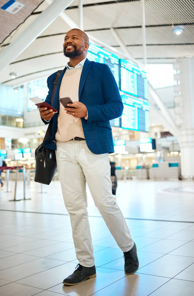 電話とチケットで空港を歩く黒人男性、ターミナルでのフライトスケジュールをチェックし、ビジネス旅行のためのパスポートを保持します。笑顔、旅行、幸せなビジネスマン国際線の目的地に搭乗. - 写真・画像