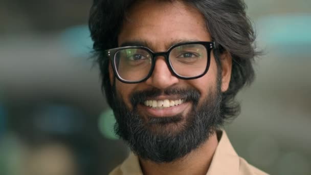 Közelkép portré boldog indiai szakállas 30-as üzletember szemüveges férfi pózol a kamera. Jóképű arab, többnemzetiségű férfi szemüvegben, üzleti vezető, mosolygó fogas mosollyal. Vidám munkaadó - Felvétel, videó