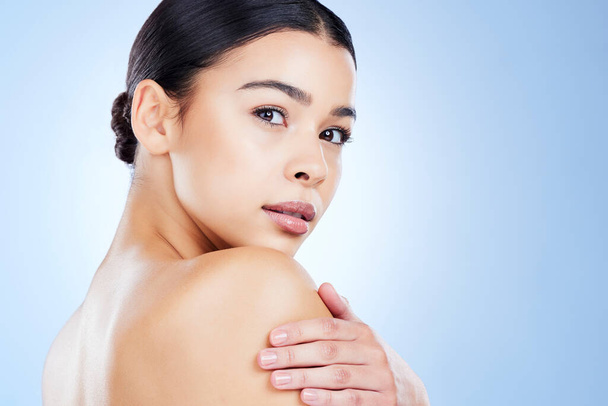 Portrait, aesthetic and mockup with a model black woman in studio on a blue background for skincare. Face, beauty and spa with an attractive young female posing next to blank or empty mock up space. - Foto, Bild