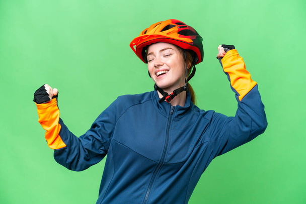 Young cyclist woman over isolated chroma key background celebrating a victory - Foto, afbeelding