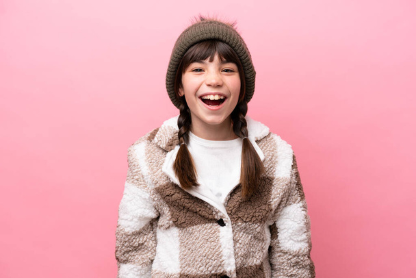 Μικρό καυκάσιο κορίτσι με χειμωνιάτικο σακάκι απομονωμένο σε ροζ φόντο με έκφραση έκπληξη στο πρόσωπο - Φωτογραφία, εικόνα