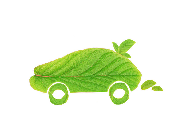  samochód z zielonymi liśćmi na białym tle. Koncepcja ekologicznego samochodu. Koncepcja ograniczenia emisji CO2 z pojazdów.Symbolizuje potrzebę inwestowania w alternatywne rozwiązania paliwowe dla transportu. - Zdjęcie, obraz