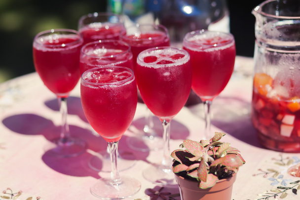 Beautiful line of different colored cocktails with smoke on a Christmas party, tequila, martini, vodka, and others on decorated catering bouquet table on open air party - Фото, изображение