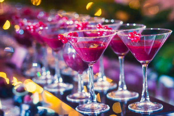 Beautiful line of different colored cocktails with smoke on a Christmas party, tequila, martini, vodka, and others on decorated catering bouquet table on open air party - Fotografie, Obrázek