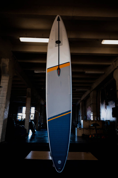 Bunte aufblasbare Stand Up Paddle Board SUP an der Wand. Surf- und Surf-Ausrüstung hautnah. - Foto, Bild