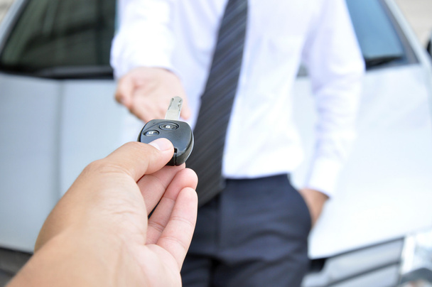 Рука, дающая ключ от машины другому мужчине
 - Фото, изображение