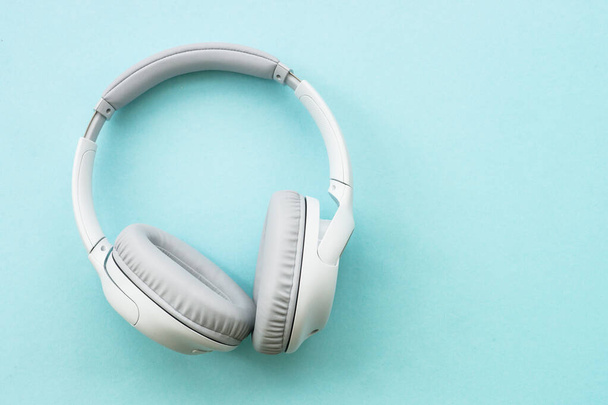 Wireless Headphones on blue background. Flat lay with copy space. - 写真・画像