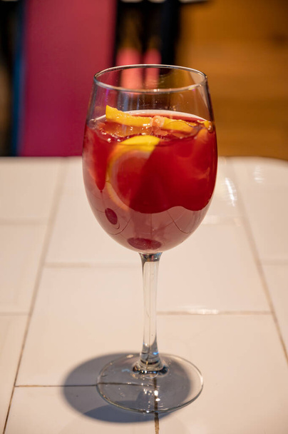 Glass of cold sangria wine served with orange in old bar in San Sebastian, Basque Country, Spain - Foto, afbeelding