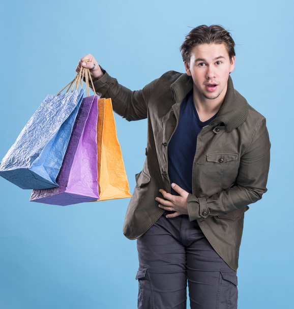 Lachende knappe man met shopping tassen - Foto, afbeelding