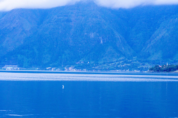 θέα στον ορίζοντα της λίμνης toba το πρωί με συννεφιασμένο καιρό - Φωτογραφία, εικόνα