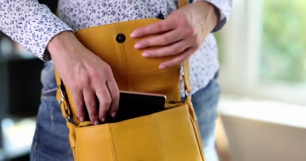 Woman taking mobile phone out of her leather purse closeup 4k movie slow motion. Emergency calls concept - Materiaali, video