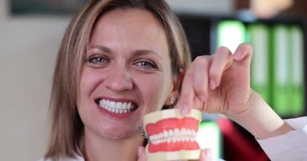 Doctor tandarts opening mond en kunstmatige plastic kaak model 4k film slow motion. Begrip tandheelkundige verzorging - Video