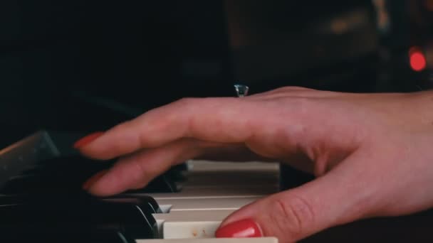 Female hands with fingers play the piano keyboard close-up side view. The piano keys are black and white. Musical instrument, spiritual education, calm music. - Filmagem, Vídeo