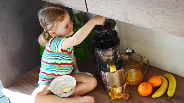 Маленька дівчинка робить свіжий сік, сидячи на столі на кухні. Високоякісні 4k кадри
 - Кадри, відео
