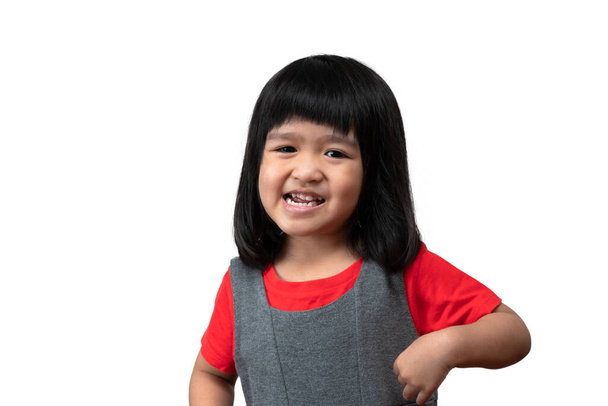 Beyaz arka planda mutlu ve komik Asyalı kız çocuğu portresi, kamera önünde el hareketine bakan bir çocuk. Anaokulu çocuğu enerjiyle dolu sağlıklı ve iyi bir konsept hayal ediyor. - Fotoğraf, Görsel