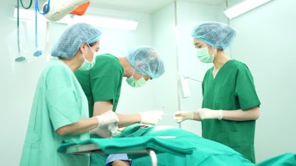 Professionele chirurgen team uitvoeren van chirurgie in de operatiekamer, chirurg, assistenten, en verpleegkundigen uitvoeren van chirurgie op een patiënt, gezondheidszorg kanker en ziekte behandeling concept - Video
