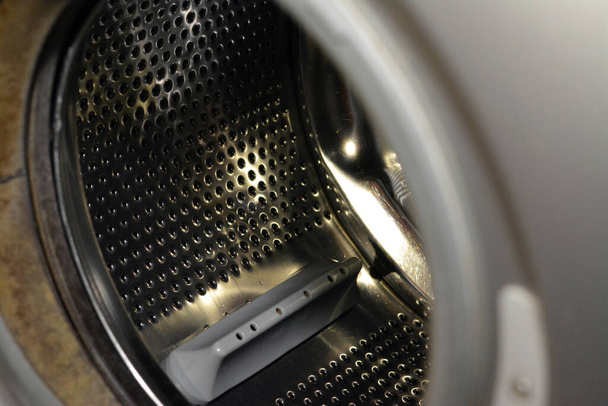 Tambour de machine à laver en acier inoxydable avec une porte ouverte de la rondelle, entretien de la machine à laver, concept de fixation et de remplacement, mise au point sélective - Photo, image