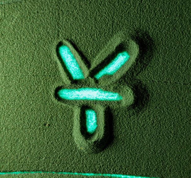 Mano che disegna il simbolo di valuta di Yuan nella Sabbia Verde. Mano maschile scrive il simbolo della valuta Yuan sulla sabbia verde con retroilluminazione blu. Risoluzione 4k vista dall'alto - Foto, immagini
