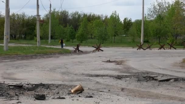 Kharkiv, Kharkov region, Rogan, Ukraine - 05.10.2022: This video shows the aftermath of a rocket attack that resulted from Russian aggression. The road is in ruins, but amidst the devastation, cars - Záběry, video