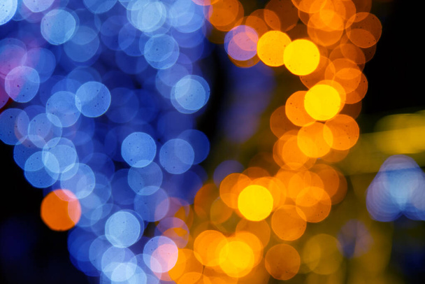 achtergrond wazig abstractie van gekleurde lantaarns en decoraties. bokeh textuur van straat gekleurde lichten - Foto, afbeelding
